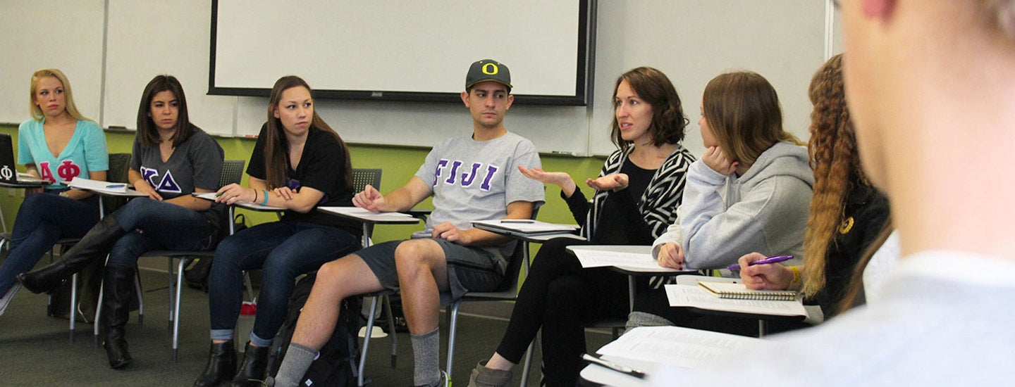 Leaders from Fraternity and Sorority Life meet in a circle of desk with their Greek letters on their shirts.