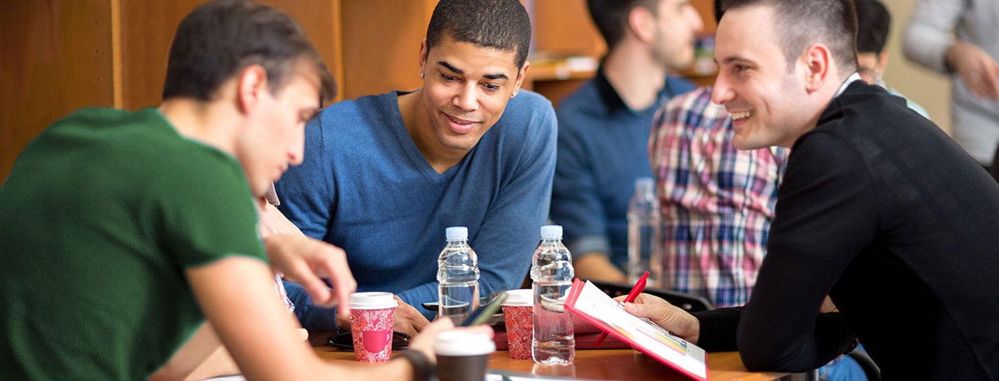 Male students work together in groups.