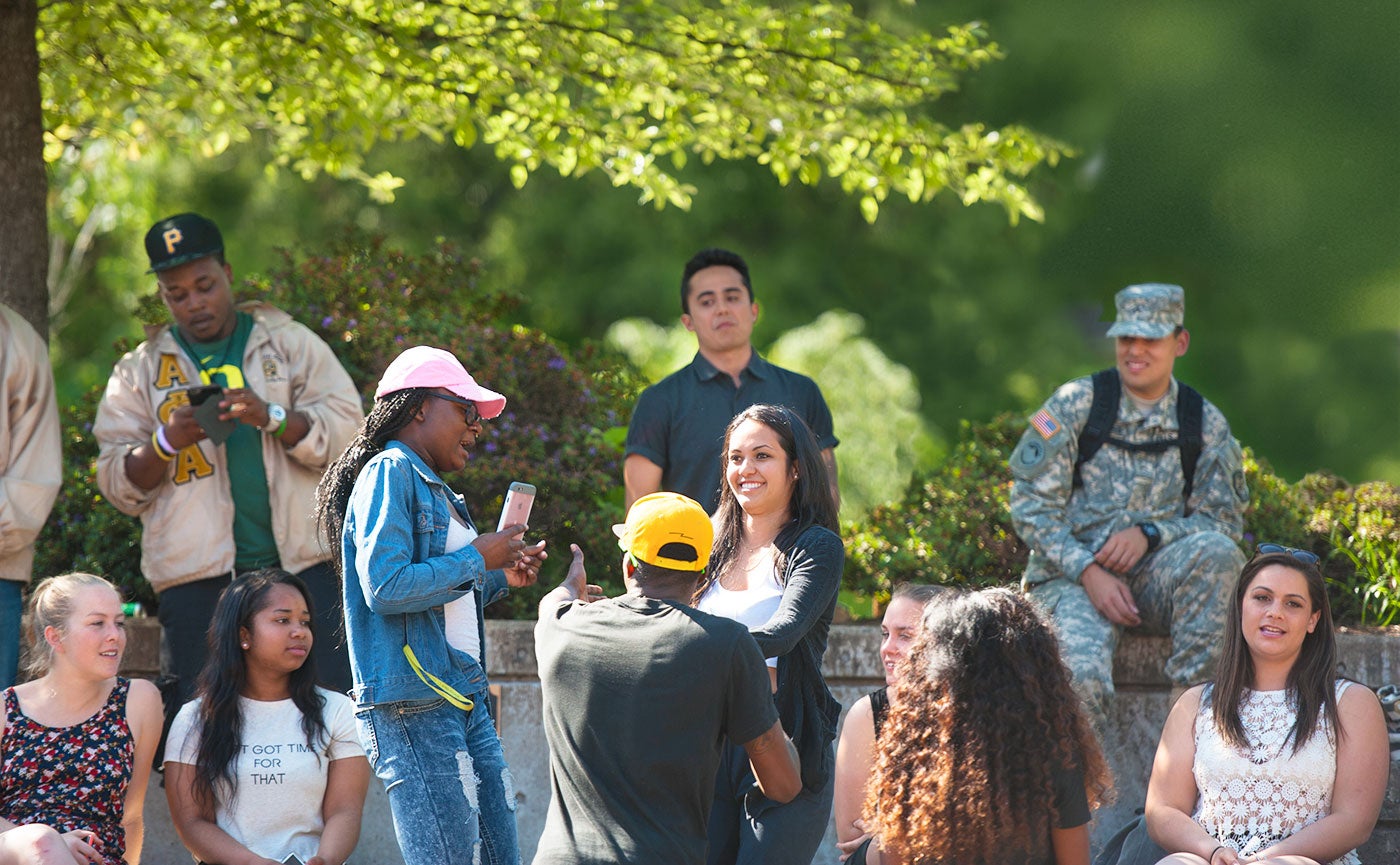 A diverse group of students hang out together in the Erb Memorial Union amphitheater.